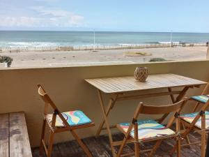 stół i krzesła z widokiem na plażę w obiekcie L'Océan&Dunes vue à 180° en bord de plage w mieście Lacanau-Océan