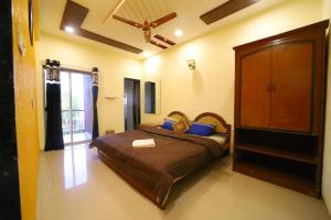 a bedroom with a large bed with blue pillows at THE CROFT HOUSE MAHABALESHWAR in Mahabaleshwar
