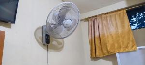 a white fan hanging on a wall next to a window at Hospedaje Mirador Grecia in Leticia