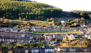 uma pequena cidade com casas e uma colina em Cottage by Rhigos Mountains em Treherbert