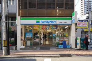 a familymart store on a city street with people standing outside at 川HOUSE黒門 in Osaka