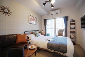 a bedroom with a bed and a couch and a window at 川HOUSE黒門 in Osaka