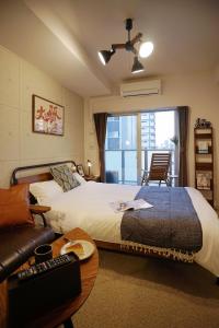 a hotel room with a bed and a couch and a window at 川HOUSE黒門 in Osaka