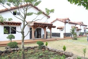 a house with a garden in front of it at Bijarim Midam Pension in Jeju