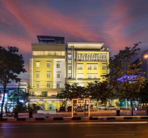 een hoog geel gebouw 's nachts met een straat bij BEST WORLD KINDAI HOTEL in Banjarmasin