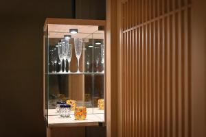 un armario de cristal con gafas y jarrones expuestos en Shima Onsen Yoshimoto, en Nakanojo