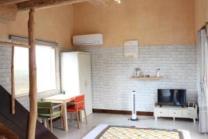 a living room with a tv and a table and chairs at Bijarim Midam Pension in Jeju +11 photos