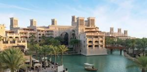 a rendering of a resort with a boat in the water at Madinat Jumeirah Living, MJL Dubai in Dubai