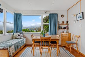 a bedroom with a table and chairs and a bed and a window at The Blue Bach - Lake Rotoiti Holiday Home in Rotoiti