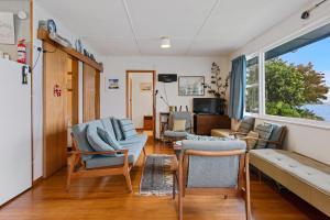 a living room with a couch and chairs at The Blue Bach - Lake Rotoiti Holiday Home in Rotoiti