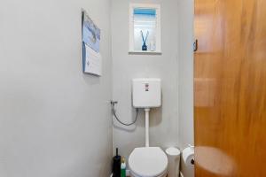 a small bathroom with a toilet and a window at The Blue Bach - Lake Rotoiti Holiday Home in Rotoiti +10 photos