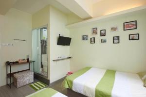 ein Schlafzimmer mit einem Bett und einem TV an der Wand in der Unterkunft Wai fan Guest house in Hongkong