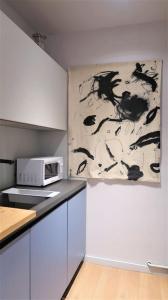 uma cozinha com um micro-ondas e um quadro na parede em Bella Easo Apartamento em San Sebastián