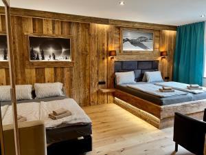 2 Betten in einem Zimmer mit Holzwänden in der Unterkunft Pension U Studny in Harrachov