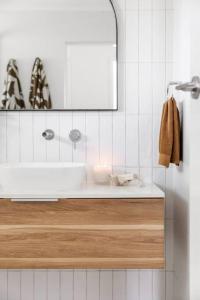 een badkamer met een wastafel en een spiegel bij The Aura House in Tweed Heads