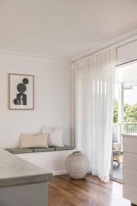 een witte woonkamer met een raam en een tafel bij The Aura House in Tweed Heads