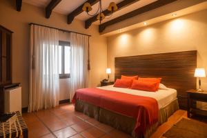a bedroom with a large bed with orange pillows at Hotel Boutique Balcón de la Plaza in Salta