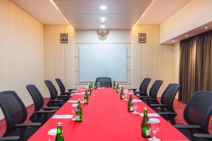 a long table in a room with chairs and a white screen at BEST WORLD KINDAI HOTEL in Banjarmasin