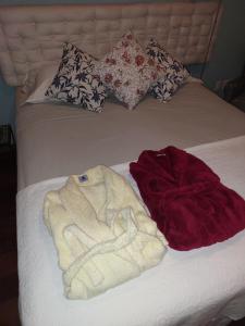 - un lit avec des serviettes et des oreillers dans l'établissement Quartos em Laranjeiras, à Rio de Janeiro