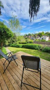 ławkę i krzesło na drewnianym tarasie w obiekcie Beautiful House And Elevated Garden In Bridgnorth w mieście Bridgnorth