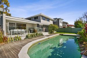 une maison avec une piscine en face d'une maison dans l'établissement Diamond Head Manor, à Budgewoi