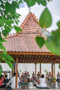 a group of people sitting in a gazebo at Umadhatu Resort by Amerta in Tabanan