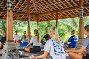 a group of people sitting in a yoga class at Umadhatu Resort by Amerta in Tabanan