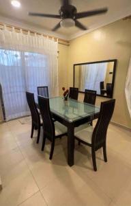 a dining room table with chairs and a mirror at Homestay by Tas in Kulai