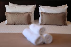 a bed with two towels on it with pillows at Blue Waves Resort in Malinska