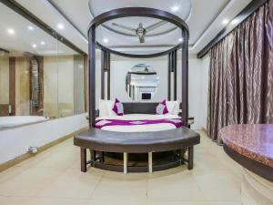 a bedroom with a bed and a tub and a mirror at Grandeur De Sanchi- Luxury Beach Resort & Spa in Calangute