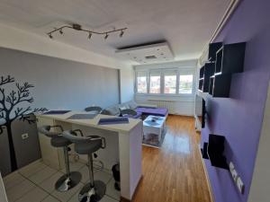 a living room with a desk and a purple wall at Harmony Apartment in Belgrade