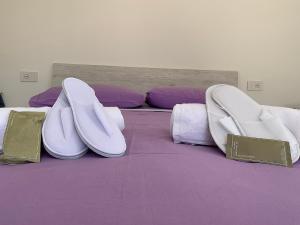 a bedroom with a purple bed with two white chairs at LA CROISETTE Agriturismo - Farmhouse in Dorgali