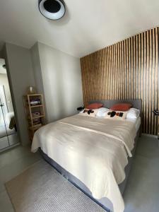 a bedroom with a large white bed with a wooden headboard at HELove Apartamenty in Hel +27 photos