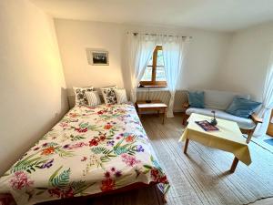馬克特謝倫貝格的住宿－Auszeitshäusel ideal für Naturfreunde und Wanderer，一间卧室配有一张床和一张沙发