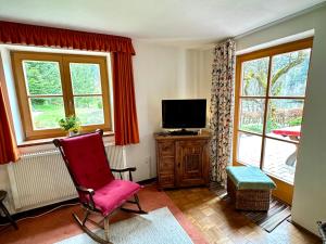 マルクトシェレンベルクにあるAuszeitshäusel ideal für Naturfreunde und Wandererのリビングルーム(赤い椅子、テレビ付)