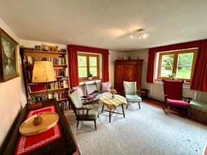 a living room with red curtains and a table and chairs at Auszeitshäusel ideal für Naturfreunde und Wanderer in Marktschellenberg