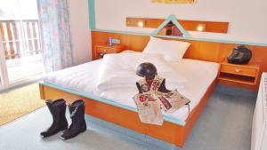 ein Schlafzimmer mit einem Bett mit Stiefeln drauf in der Unterkunft Motel Brunner Apartments & Zimmer in Bad Eisenkappel