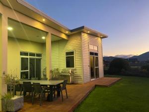 a house with a table and chairs on a deck at Luxury on Howden in Te Anau