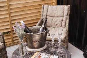 a bucket of wine sitting on a table with glasses at Matamata Country B&B in Matamata +32 photos