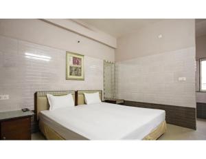 - une chambre avec un grand lit blanc et 2 oreillers dans l'établissement Jay Shanti Palace, Dewas, à Dewās