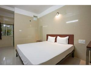 - une chambre avec un grand lit et des draps blancs dans l'établissement Jay Shanti Palace, Dewas, à Dewās