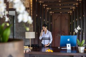 eine Frau, die an einem Schreibtisch steht und telefoniert in der Unterkunft The Kayon Valley Resort in Ubud + 154 Fotos