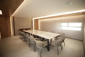 une salle de conférence avec une grande table et des chaises dans l'établissement The Maximilian Hotel, à Cauayan