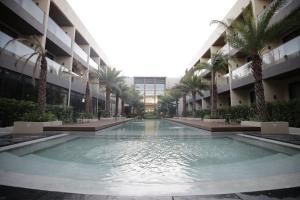 una piscina en medio de un edificio con palmeras en The Maximilian Hotel en Ciudad de Cauayán
