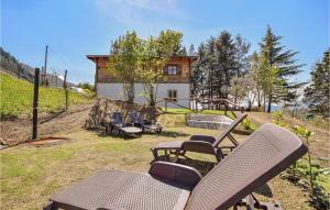 un cortile con sedie e una casa con parco giochi di Nice Home In Sillano With Outdoor Swimming Pool, Wifi And 2 Bedrooms a Sillano