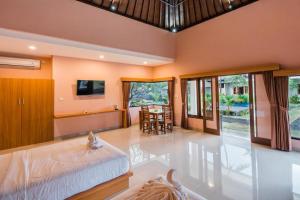 - une chambre avec un lit, une table et des chaises dans l'établissement Ariana Beach Resort Amed Bali, à Amed