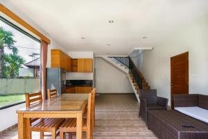 cocina y comedor con mesa de madera y sillas en Ariana Beach Resort Amed Bali, en Amed