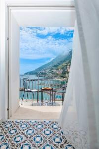 a room with a view of the ocean from a window at Casa del Duca in Amalfi