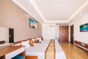 ein Hotelzimmer mit einem Bett und einem TV in der Unterkunft Maldives Hotel - FLC Sầm Sơn in Sầm Sơn