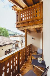 einen Balkon mit Stühlen und einem Tisch auf einem Gebäude in der Unterkunft Hotel Schmuckhof in Klausen